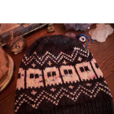 Two-color beanie with a row of little ghosts. Above and below are colorwork zigzags and plus signs.