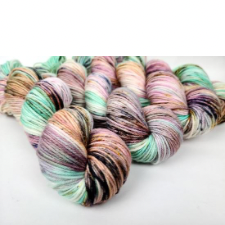 Highly variegated yarn featuring mint, muted purples and deep browns.