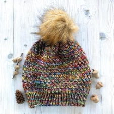 Slip-stitch hat in variegated yarn with faux fur pom-pom and ribbed brim.