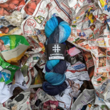 Light and dark blue variegated yarn, shown on bed of crumpled newspaper