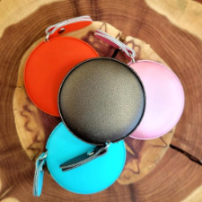 Four nicely finished vegan leather measuring tapes in red, pink, blue and black.