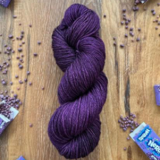Purple yarn surrounded by identically hued Nerds candy bits.