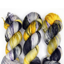 Variegated sock yarn in shades of black, white and gold.
