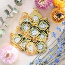 Enamel stitch markers with a golden depiction of the Sun God.