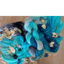 Varigated yarn in true blue and aqua, sprinkled with dried flower petals.