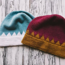 Colorwork hats in gold and maroon and blue and white. Brim is worked in accent color in a crown shape.
