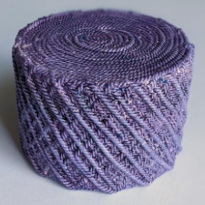 Screw-top container that looks like a yarn cake.