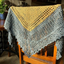 Mitered triangular crocheted shawl in several closed and openwork designs.