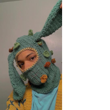 Crocheted balaclava has long, droopy bunny ears, as well as appliques that look like leaves, lichen, etc.