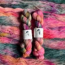 Bright variegated skein in deep pinks, warm oranges and golds, and cool blue-green.