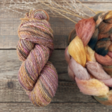Gently variegated yarn in warm fall colors, next to a roving braid in the same colors.
