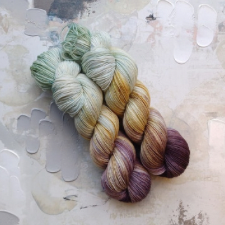 Variegated skein goes from palest blue-green to gold to deep dusty purple.