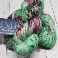 Mint yarn with cranberry splashes and deep green speckles.