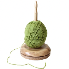 Cake of yarn on center spike. Two wood plates at the base let the butler turn as you knit or crochet.