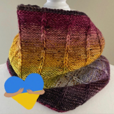 Cowl knit inside out with purl sections separated by slipped knit stitches. Heart with arms hugging it in the colors of the Ukraine flag indicate that proceeds benefit Ukraine.