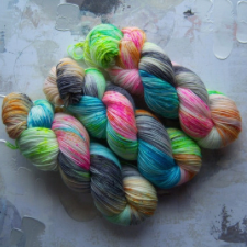 Bright blue, green and pink yarn, approaching neons, with gray and cream for balance.