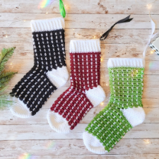 Three christmas stockings that are a solid color with white dots throughout, then white cuffs, heels and toes.