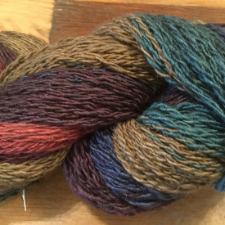 Variegated yarn in dusty shades of coral, teal, midnight blue, brown and khaki.