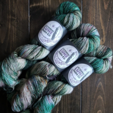 Variegated yarn in white, deep green, pale rose and taupe.