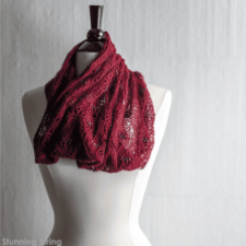 Deep delicate cowl in curving lace patterns that falls into folds.