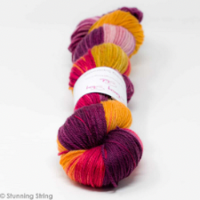 Variegated yarn in maroon, bright red, pink and gold.