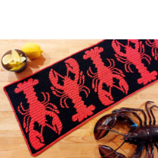 Table runner with lobsters alternating heads and tails in red on black.