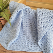 Pale blue blanket in crossed double crochet with border.