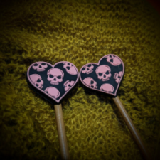 Heart shaped needle stops with pink skull pattern repeat.