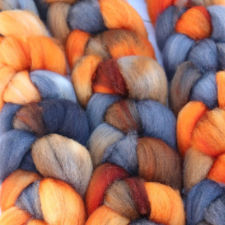 Braids of fiber with orange, slate blue, russet and brown.