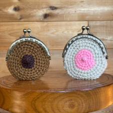 Round snap-closure coin purse shown in white and brown with textured nipple.