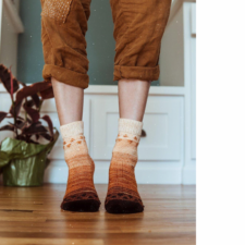 Socks with colorwork “bubbles” at the top and bottom. Colors start dark brown at the toe and transition slowly to cream at the top of the socks.