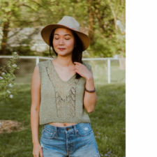 Woman in garden wears sun hat and loose-fitting V-neck stockinette and lace tank.