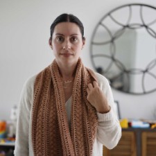 Long cowl with alternating puffy braided cables and lace that run the perimeter.