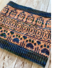 Colorwork cowl with light orange background and deep blue motifs of dog paws, fire hydrants and dog faces.