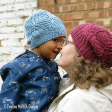 Mother and small child wear a hat with a texture broken into triangles. Each triangle has ribs running either horizontally or vertically.