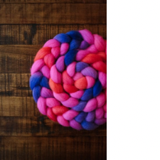 Coiled braid of pinning fiber in bright pink, orange and blue with hints of blue violet.