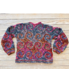 Crocheted sweater in multicolor yarn has long sleeves, crew neck and spiral motif throughout.