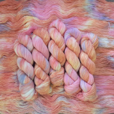 Gently variegated yarn in pale corals and golds, with touches of lavender and blue.