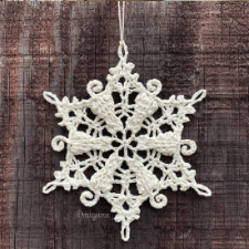 A snowflake that includes clever cats facing center with their curled tails joining the outline of the snowflake.