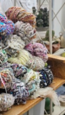 A stack of handspun yarns, mainly in soft colors.