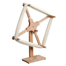 Vertical wooden device with skein held on four pegs.