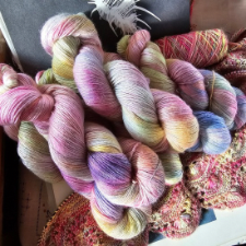 Muted pinks, purples, blues, white and yellow in 50-50 merino and silk.