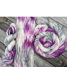 Gray, purple and white variegated shown hanked, swirled and unhanked.